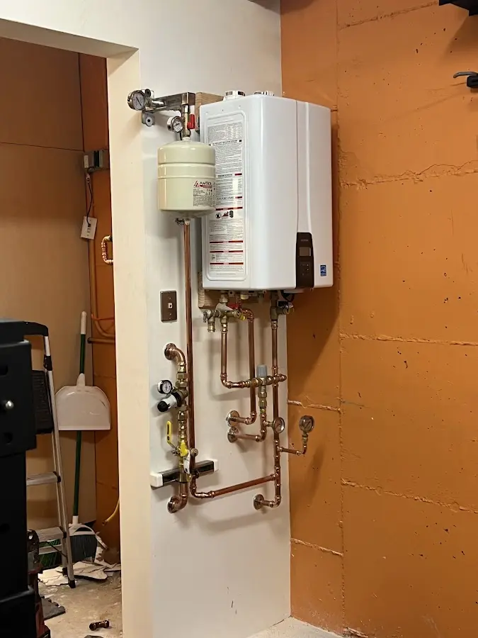 Plumbing technician inspecting water heater connections in Santa Fe